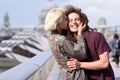 Happy couple hugging by Millennium bridge, River Thames, London. Royalty Free Stock Photo
