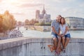 Happy couple hugging near Notre-Dame cathedral in Paris. Tourists enjoying their vacation in France. Romantic date or Royalty Free Stock Photo