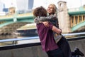 Happy couple hugging near the Southwark bridge over River Thames, London Royalty Free Stock Photo