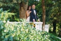 Happy couple hugging in the park. The bride in a black suit and bride in a beautiful white wedding dress. Marriage day. Royalty Free Stock Photo