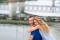 Happy couple hugging while sitting on the bank of the river on summer Royalty Free Stock Photo