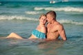 Happy couple hugging during sitting in sea water on the beach Royalty Free Stock Photo