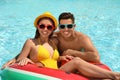 Couple with inflatable ring in swimming pool. Summer vacation