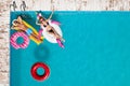 Happy couple with inflatable rings and mattress in swimming pool. Summer vacation