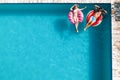 Happy couple with inflatable rings in swimming pool, space for text. Summer vacation Royalty Free Stock Photo