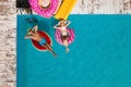 Couple with inflatable rings in swimming pool, top view. Summer vacation