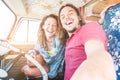 Happy couple inside minivan for a road trip - Adult people taking selfie on summer vacation traveling around the world - Travel, Royalty Free Stock Photo