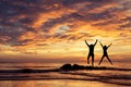 Happy couple jumping on the beach on the sunset time. Royalty Free Stock Photo