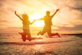 happy couple jumping on beach