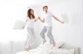 Happy couple jumping and having fun in bed Royalty Free Stock Photo