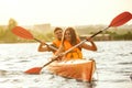 Happy couple kayaking on river with sunset on the background Royalty Free Stock Photo