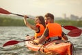 Happy couple kayaking on river with sunset on the background Royalty Free Stock Photo