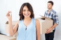 Happy couple with key and boxes moving to new home Royalty Free Stock Photo