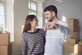 Happy couple with keys to new home in hands smiling while standing in room. Royalty Free Stock Photo