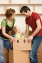 Happy couple with a kid unpacking in a new home Royalty Free Stock Photo