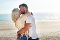 Happy, couple and kiss on beach with love for holiday romance, summer travel and ocean view with affection. Man, woman