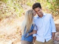 Happy couple, kiss and hug in nature for love, support or affection in outdoor walk or bonding. Young woman and man on Royalty Free Stock Photo