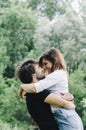 Happy couple kissing and hugging in nature. Young man and woman in loving relationship having fun in park Royalty Free Stock Photo