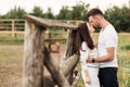 Happy couple is kissing near wooden fence. young man and woman are having fun outdoors on a warm summer day Royalty Free Stock Photo