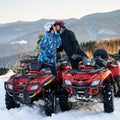 Happy couple kissing while riding quad bikes in mountains. Royalty Free Stock Photo