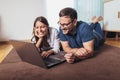 Happy couple with laptop and credit or bank card shopping online at home Royalty Free Stock Photo