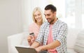 Happy couple with laptop and credit card at home Royalty Free Stock Photo