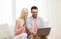 Happy couple with laptop and credit card at home Royalty Free Stock Photo