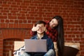 Happy couple with laptop spending time together at home, browsing internet in bed, smiling and having fun Royalty Free Stock Photo