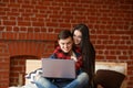 Happy couple with laptop spending time together at home, browsing internet in bed, smiling and having fun Royalty Free Stock Photo