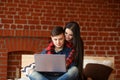 Happy couple with laptop spending time together at home, smiling and having fun Royalty Free Stock Photo