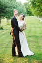 Happy couple laughing happily while cuddling each other on their wedding day in a green garden Royalty Free Stock Photo