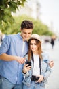 Happy young couple look at phone screen to app of tourists sightseeing in the street Royalty Free Stock Photo