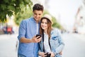 Happy young couple look at phone screen to app of tourists sightseeing in the street Royalty Free Stock Photo