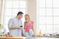 Happy couple looking at each other while drinking red wine in kitchen Royalty Free Stock Photo