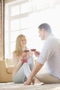 Happy couple looking at each other while having red wine at home Royalty Free Stock Photo