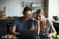 Happy couple looking at laptop screen together, laughing Royalty Free Stock Photo
