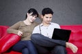 Happy couple looking at laptop on sofa Royalty Free Stock Photo