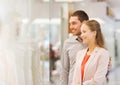 Happy couple looking to shop window in mall Royalty Free Stock Photo