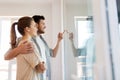 Happy couple looking through window at new home Royalty Free Stock Photo