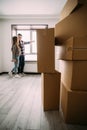 Mortgage, people and real estate concept - happy couple looking through window at new home over city buildings Royalty Free Stock Photo