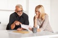 A happy couple looks at the postal bills. Mature man and woman received feedback Royalty Free Stock Photo