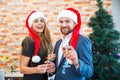 Happy couple in love in Christmas hats having fun on a blurred background. Domestic new year concept. Royalty Free Stock Photo