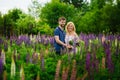 A happy couple in love embraces in a Lupin field. Blooming purple flowers of lupine