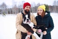 Happy couple in love having fun in the snow with his baby dog Royalty Free Stock Photo