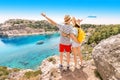 Couple in love having travel vacation and standing on top of the hill overlooking to attractive blue sea bay