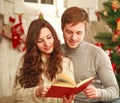 Happy couple in love in holiday home reading book together Royalty Free Stock Photo