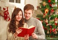 Happy couple in love in holiday home reading book together Royalty Free Stock Photo