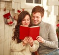 Happy couple in love in holiday home reading book together Royalty Free Stock Photo