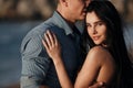 Happy couple in love during honeymoon on a rocky beach near the blue ocean