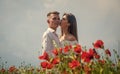 Happy couple in love kissing in beautiful field of poppy flower on romantic day, love Royalty Free Stock Photo